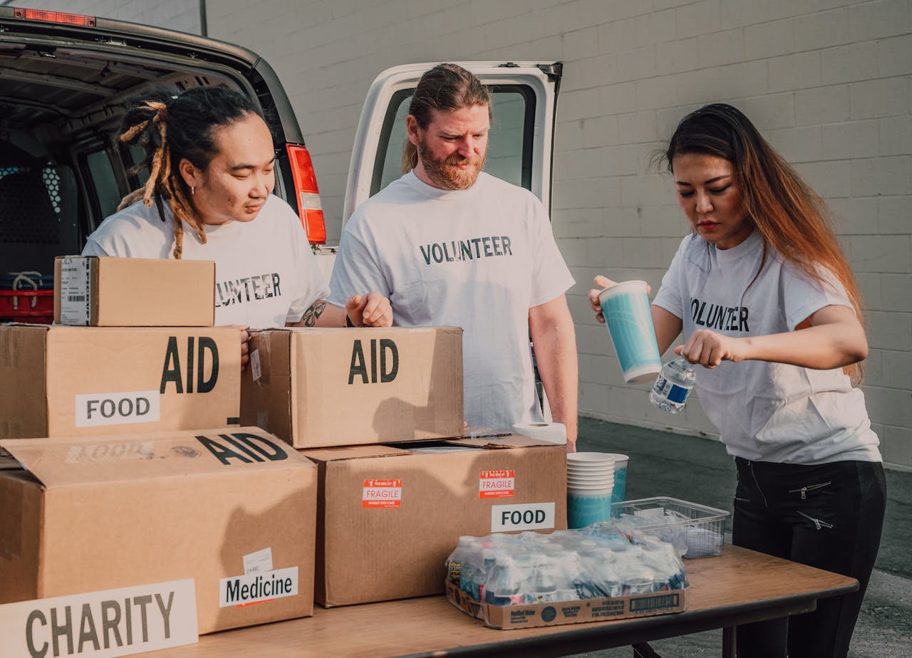 Volunteers sort aid and food boxes for a charity drive, promoting togetherness and social good.